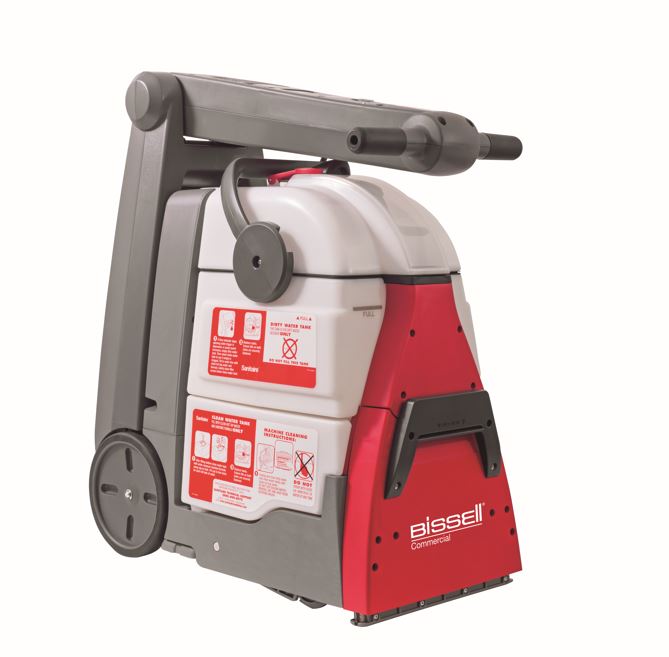 Bissell DC100 carpet cleaner shown in compact storage position with tools and hose attached