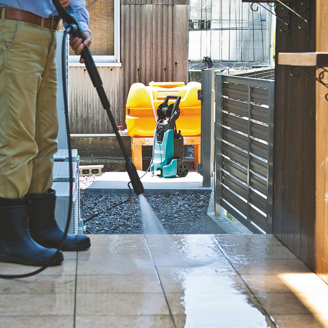 Man cleaning his patio with a Makita domestic pressure washer