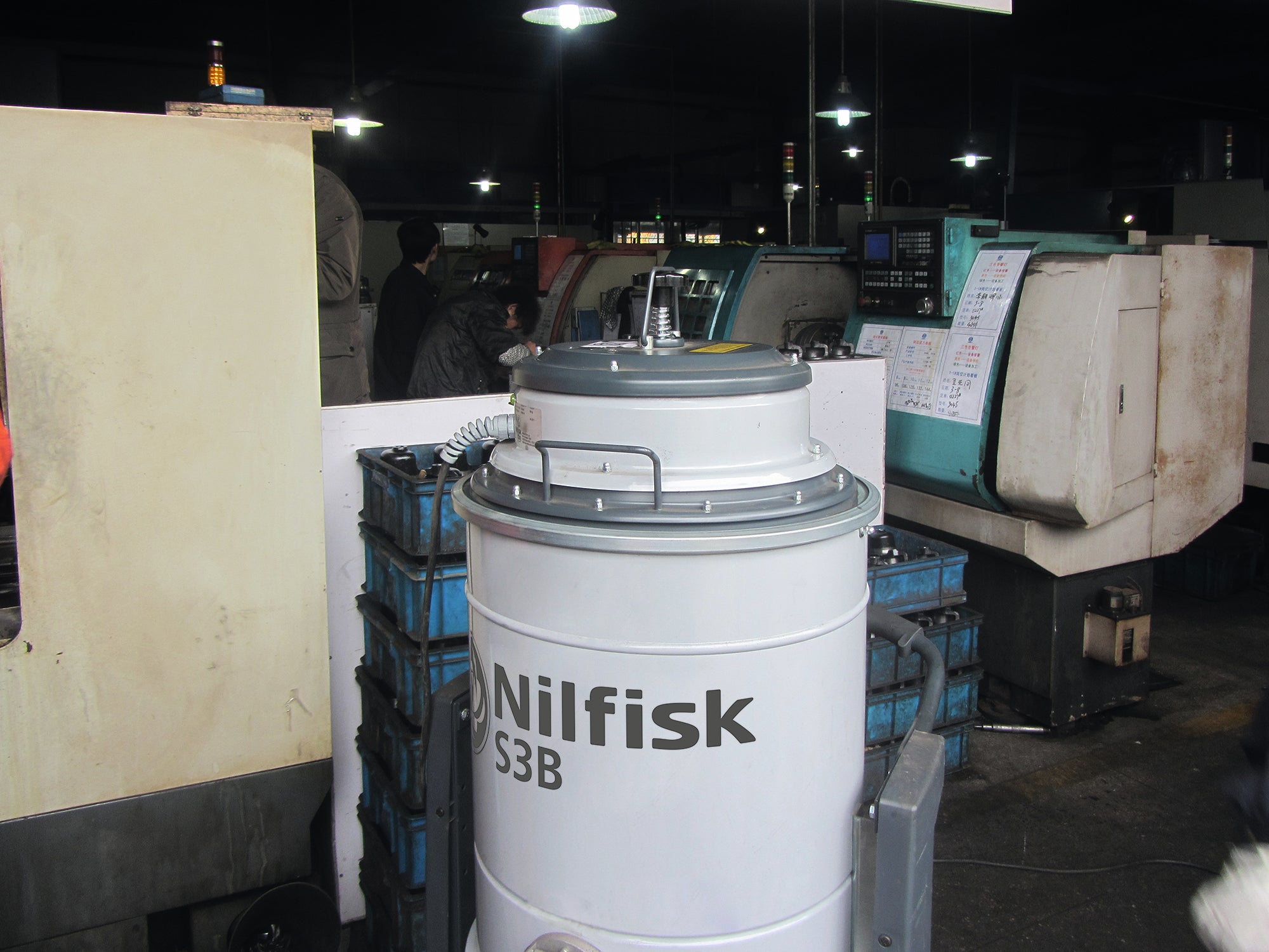 Nilfisk S3B L100 vacuum cleaner in use within an industrial warehouse environment