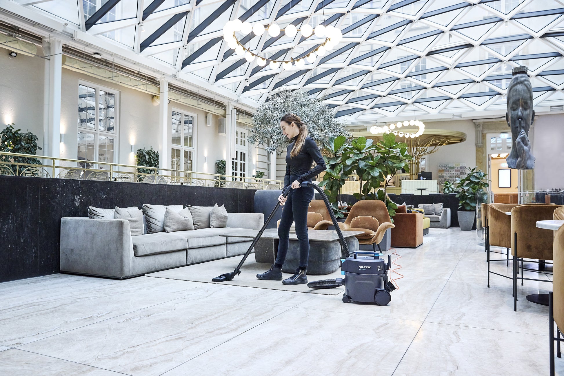 Nilfisk VP300 vacuum cleaner used in busy commercial interior for daily professional cleaning tasks