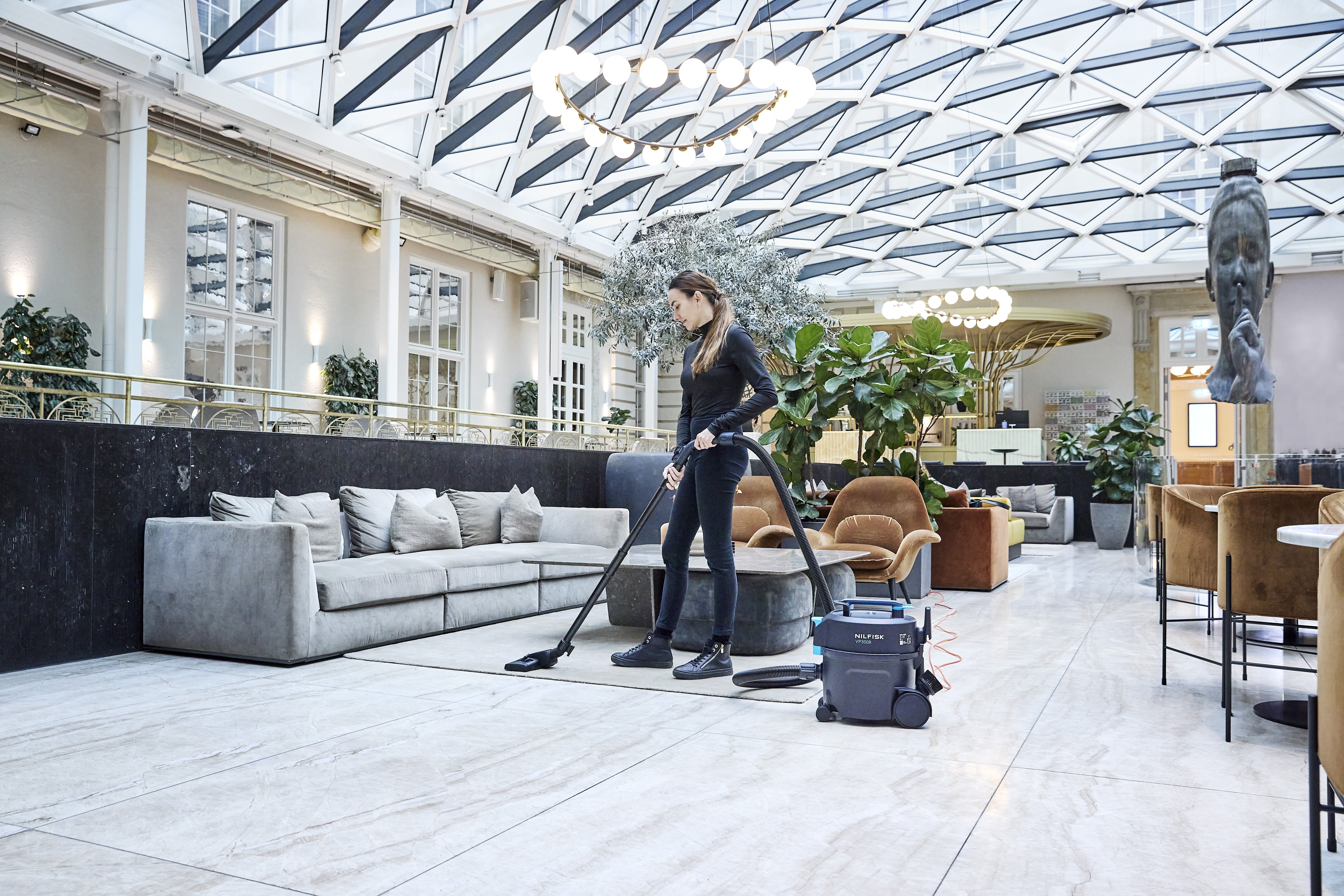 Nilfisk VP300 vacuum cleaner used in busy commercial interior for daily professional cleaning tasks