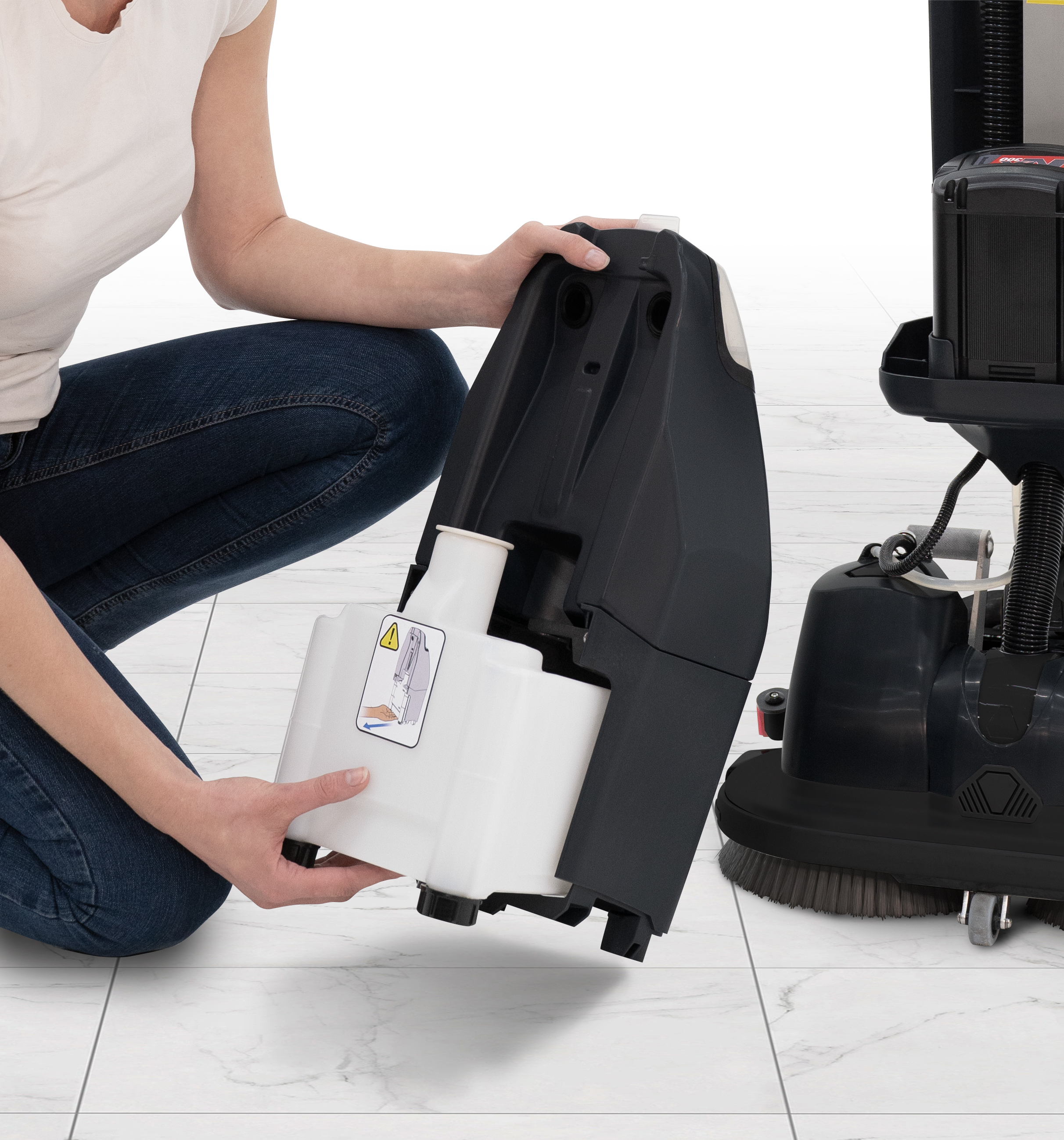 Operator removing the solution tank from the Numatic 440NX for refilling or cleaning