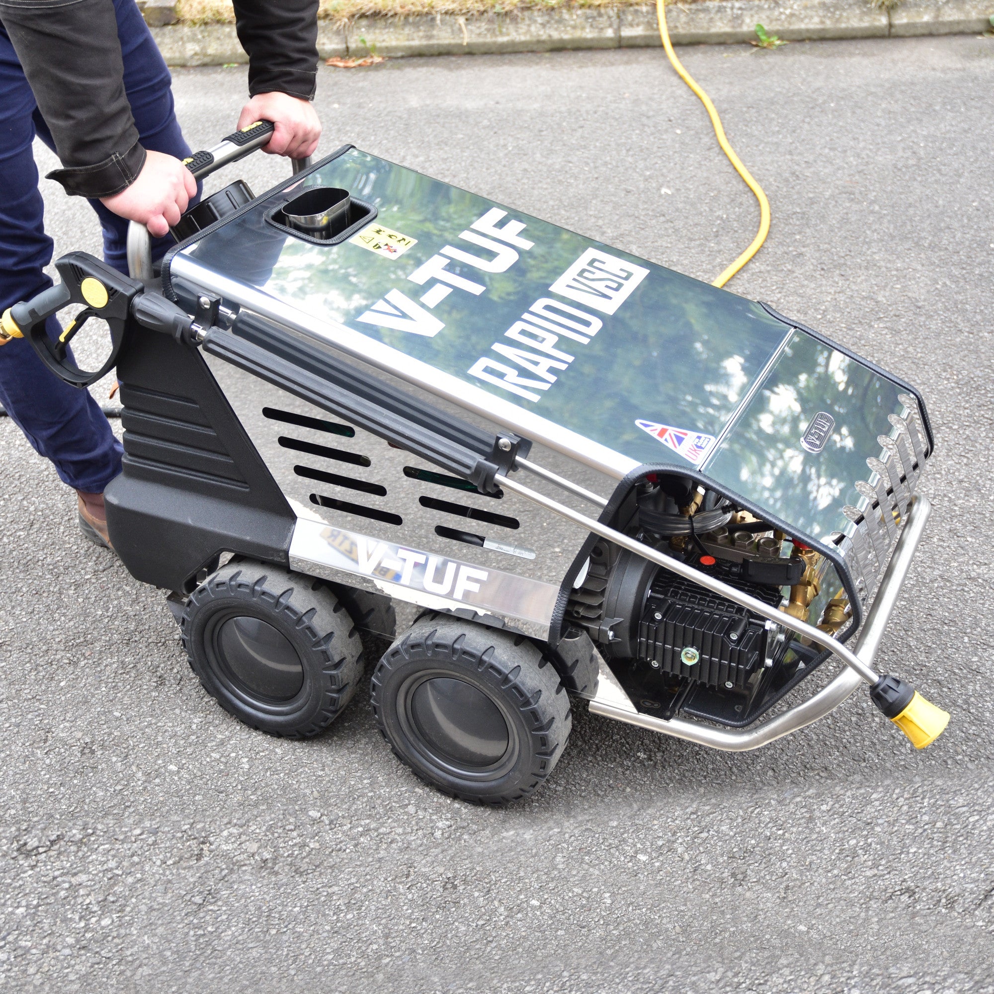 Operator using V-TUF Rapid VSC industrial hot pressure washer for heavy-duty outdoor cleaning