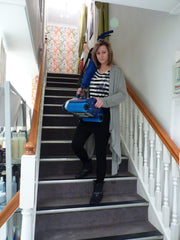 Woman effortlessly carrying the Duplex 280 Floor Cleaner down stairs, showcasing its exceptional portability and ease of use