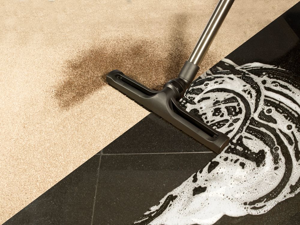 Numatic CV570 wet vacuum being used to extract liquid from a hard floor