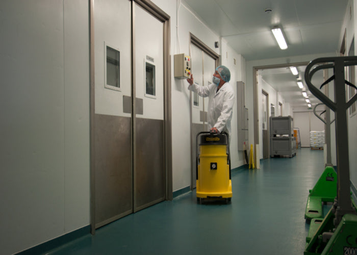 Operator using Numatic HZ900 H-Class vacuum inside commercial building for safe hazardous dust removal
